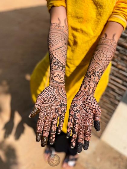 A lovely bridal mehendi with the initials A and S designed in a beautiful circular script. It's a simple way to add a personal element to a traditional full-hand design.