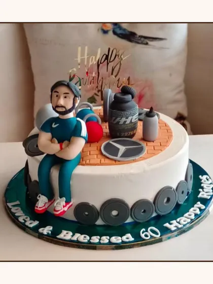A fitness-themed cake for a 60th birthday, decorated with gym equipment, weights, and a fondant figure of a fitness enthusiast.