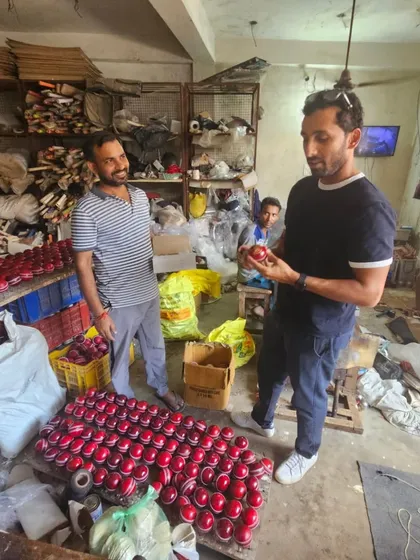 Inspecting a fresh batch of hand-stitched leather balls. The quality of the seam and the leather makes a huge difference in how the ball behaves in the air and off the pitch.