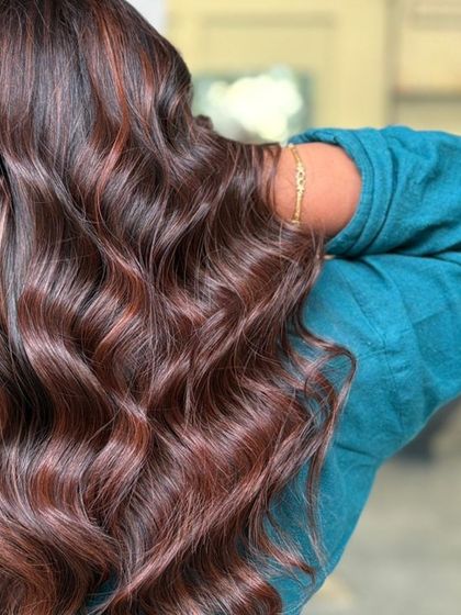 A beautiful shot over the shoulder, showcasing the rich tones and healthy shine of this wavy balayage.