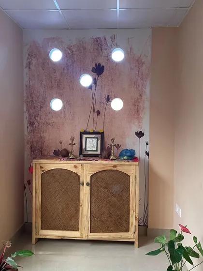 This abstract floral wallpaper was used to create a peaceful pooja or meditation corner. The simple design and rustic texture complement the wooden cabinet, creating a warm and inviting sacred space.