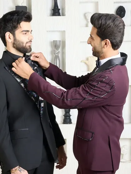 This image shows the process of getting the final look just right. Here, I am adjusting the bow tie on a client wearing the black patterned lapel tuxedo, ensuring every detail is perfect.