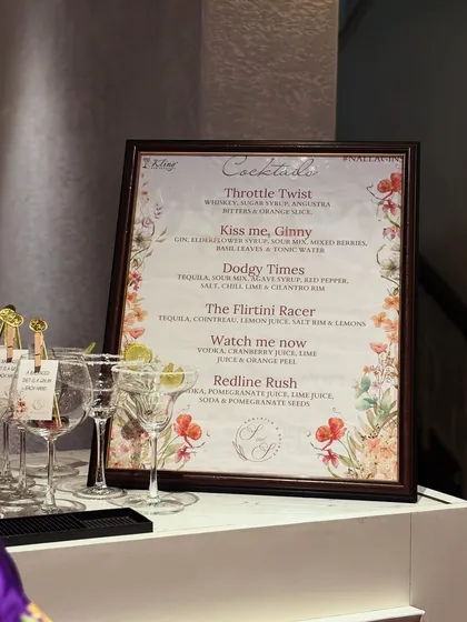 A beautifully designed floral menu featuring custom-named cocktails like 'Throttle Twist' and 'Kiss me, Ginny'. We work with you to create drink names that reflect your personality and event theme.