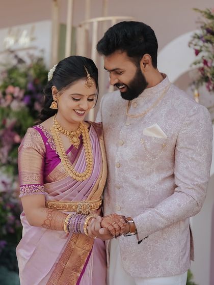 The gentle joy of a newly engaged couple. The soft pastel colors of the decor, from the bride's saree to the floral arrangements, create a harmonious and romantic picture.