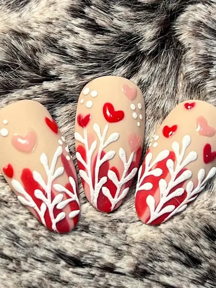 "Love is in the air." These Valentine's Day nails feature 3D hearts and delicate white branches on a matte base.
