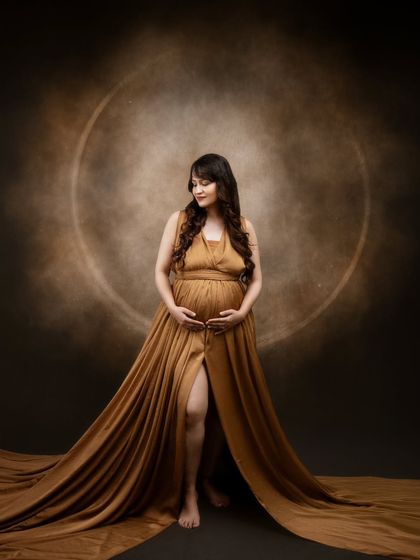Radiating love and light. This breathtaking capture shows the power of motherhood, with a stunning mama-to-be in our custom golden gown.