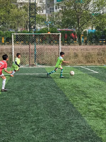 An attacker dribbles towards the goal, looking to create a scoring opportunity for the team.
