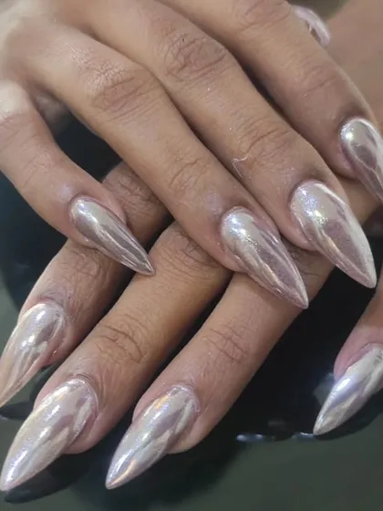 Fierce and futuristic. These long stiletto nails are coated in a brilliant silver chrome finish for a high-impact, metallic look.