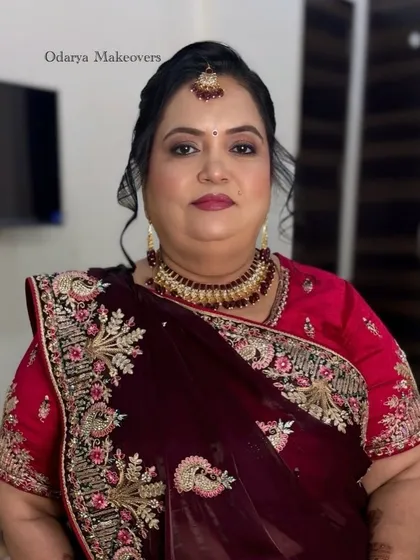 The complete wedding look for the mother of the bride. She looks absolutely regal in her maroon and red saree.