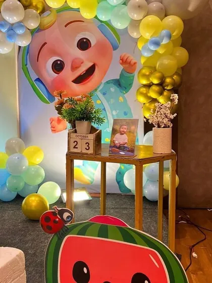 A detail shot from a Cocomelon party, showing a small table with a photo of the birthday boy and a calendar block marking the special date.
