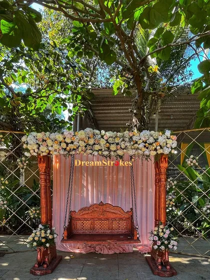 A traditional wooden swing (oonjal) decorated with flowers, providing a beautiful spot for wedding rituals or a photo opportunity for the couple.