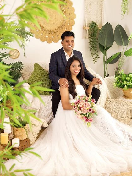 A smiling portrait of a couple during their family session. The greenery and macrame details of our boho set create a warm, natural backdrop.