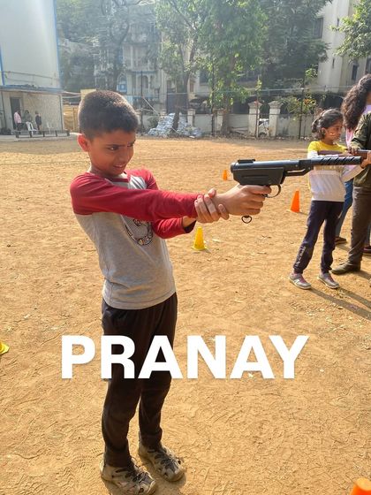 Pranay is all smiles and focus as he gets ready for his turn at the shooting activity.