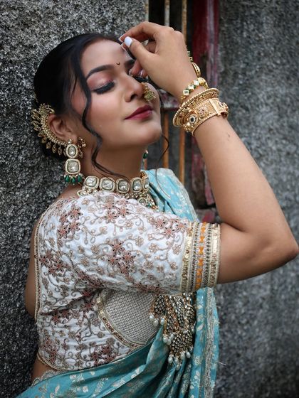 A serene, artistic shot focusing on the makeup and jewellery.
