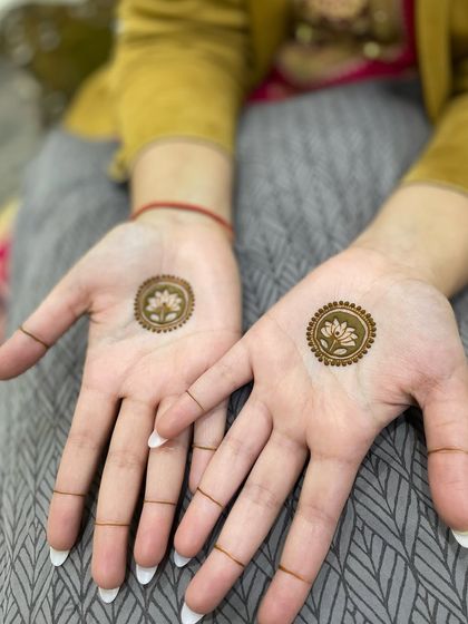 Minimalist lotus mandalas on the palms with simple henna lines on the fingers. This is a very modern and chic look.