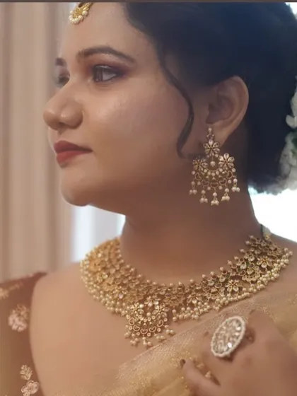 A detailed close-up of this classic bridal look. You can see the precision of the eyeliner, the soft contouring, and the beautiful antique gold jewelry that completes the style.