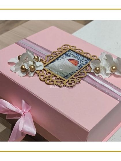 The final presentation of the baby girl gift box, featuring a personalized photo on the lid.