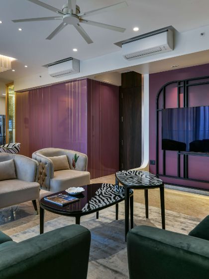 This living room design prioritizes a bold, artistic atmosphere. The rich grape color is the star, balanced by beige wallpaper and furniture that is like art itself, including a console combining wood and a Mimosa hued finish.