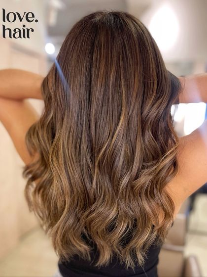 A close-up back view of the 'sugar honey serotonin' balayage, highlighting the seamless blend and the healthy shine of the hair after the service.