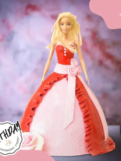 A stunning Barbie doll cake in a beautiful red and pink gown. The intricate details on the dress and the elegant pose make this a truly show-stopping centerpiece.