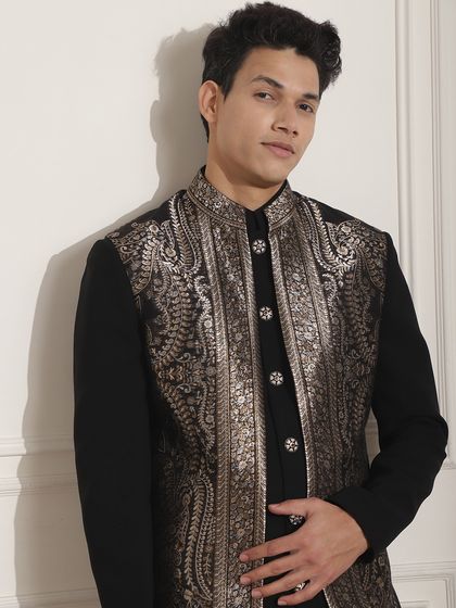 A black Indo-Western outfit with a stunning silver embroidered long jacket. This is a powerful look for a reception or cocktail party, blending tradition with high fashion.