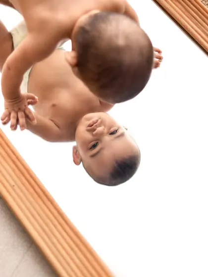 A creative shot using a mirror to create a fascinating reflection. This angle offers a unique and artistic perspective for a baby portrait.