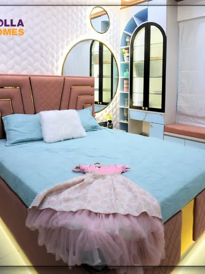The bed in the teenage girl's room features an Art Deco-inspired headboard in dusty rose with gold accents, complemented by soft blue bedding and under-bed lighting.