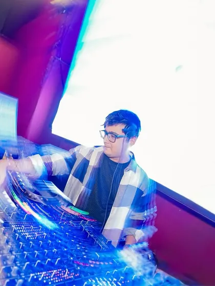 An artistic long-exposure shot capturing the motion and speed of mixing tracks. The lights and movement represent the flow of the music.