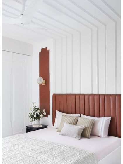 This guest bedroom in a Thane home blends comfort with elegance. The design flows seamlessly from the leather headboard to the ceiling, creating a visual harmony that is both captivating and calming.