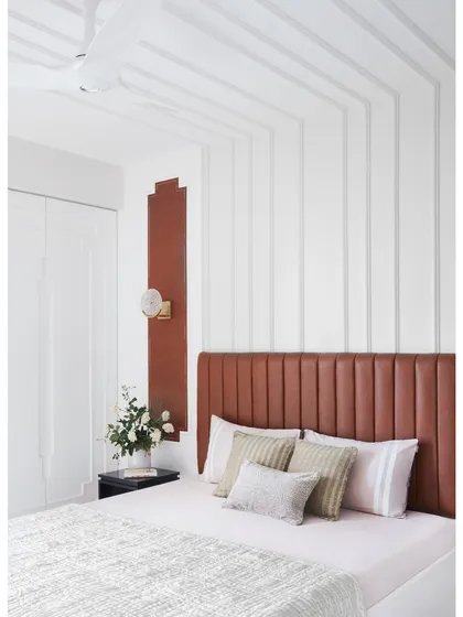 This guest bedroom in a Thane home blends comfort with elegance. The design flows seamlessly from the leather headboard to the ceiling, creating a visual harmony that is both captivating and calming.