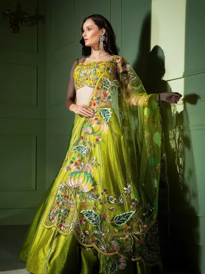 A vibrant lime green lehenga for the bride who dares to be different. The piece is covered in colorful, artistic floral embroidery, making it a true work of art.