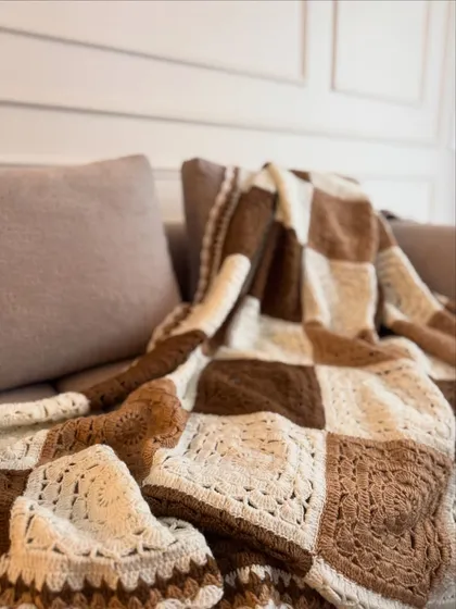 This brown and white checkered throw offers a classic, rustic charm. It's perfect for creating a cozy, farmhouse-inspired look in your living room.
