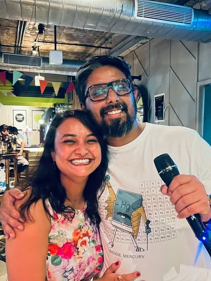 A couple shares a hug and a mic during our special Holi karaoke night, a perfect blend of celebration and music.