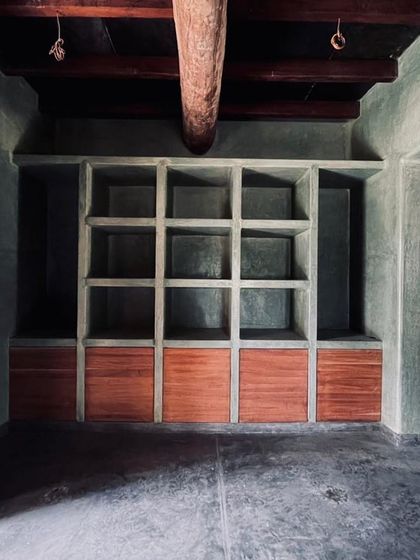 Custom built-in storage at the Hassan farmhouse, where the coolness of cement plaster contrasts with the warmth of wood.