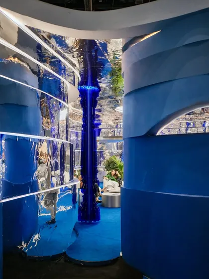 From this angle, you can see how the layered blue waves on the wall interact with the reflective chrome surfaces. This interplay of solid color and distorted reflection was key to creating a space that felt both grounded and otherworldly.