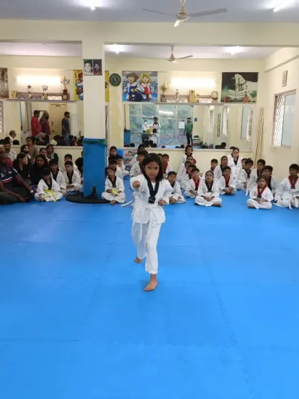 A single student takes the floor, demonstrating her Poomsae with focus and precision in front of her peers and the examiners.