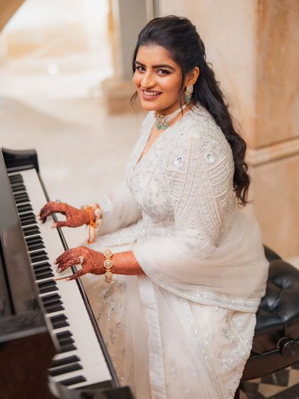 A quiet moment for the bride before her Sangeet. This shot shows the beautiful detailing on her ivory zardozi jacket and her elegant emerald and diamond choker, a perfect combination for an evening of music and dance.
