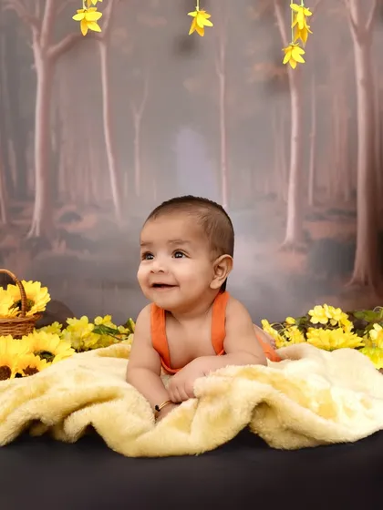 A precious tummy-time shot on a soft yellow blanket, set against the forest backdrop. This pose is great for younger babies who are not yet sitting up on their own.
