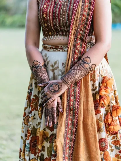 A mid-shot showing how the henna design on the arms enhances the overall festive attire.