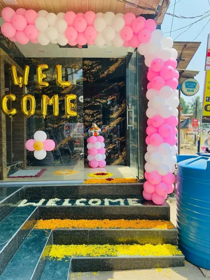 A shop-front style welcome decoration for a home, with a pink and white balloon arch and 'WELCOME' foil letters.