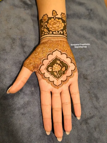 A modern take on engagement mehndi, with a bold floral cuff and a matching motif on the palm. The negative space makes the design stand out.