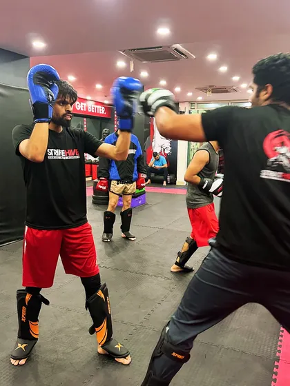 A close-up of a sparring exchange, showing the focus and technique involved. Students wear protective gear, including shin guards and gloves, to ensure a safe training environment.