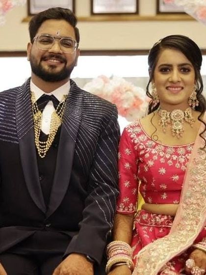 A happy couple at their reception. The bride is wearing a beautiful pastel pink choker set that matches her lehenga perfectly.