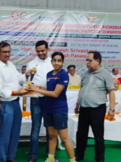 **A Champion's Recognition.** Divyanshi receiving her trophy at the U.P. State tournament after winning gold in Girls' Singles and Girls' Doubles.