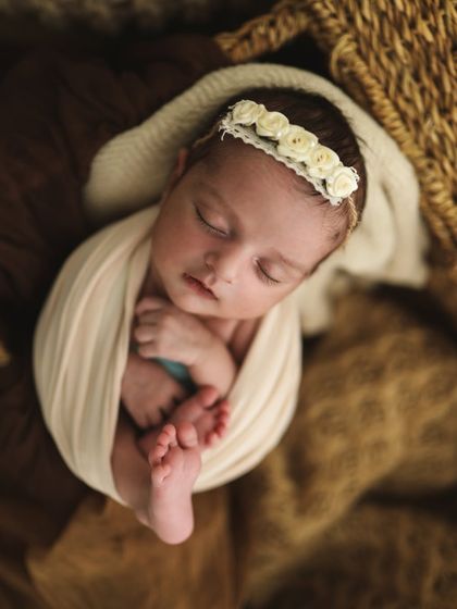 So adorable! The simple white headband with little roses is the perfect delicate accessory for a newborn girl.
