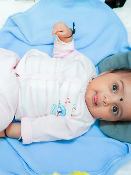 A sweet baby girl looking at the camera during her naming ceremony. A beautiful, natural portrait from a family event.
