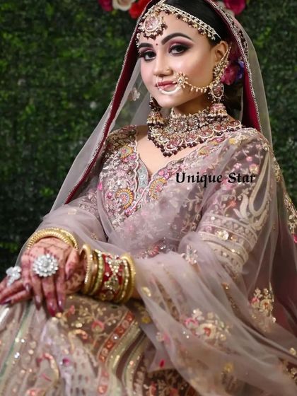 A professional shot of a model in a dusty pink floral lehenga. This look is perfect for a modern bride who wants an elegant and sophisticated outfit.