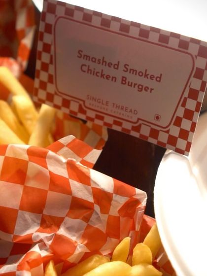 The sign for our "Smashed Smoked Chicken Burger" promises a flavorful experience. This close-up shot, with golden fries in the background, makes the offering tangible and tempting.