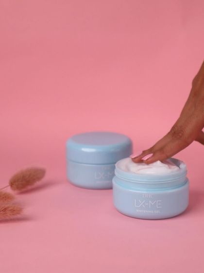 Adding a human element to the shot. A finger dipping into the cream makes the product more relatable and tempting, showing off its rich texture.