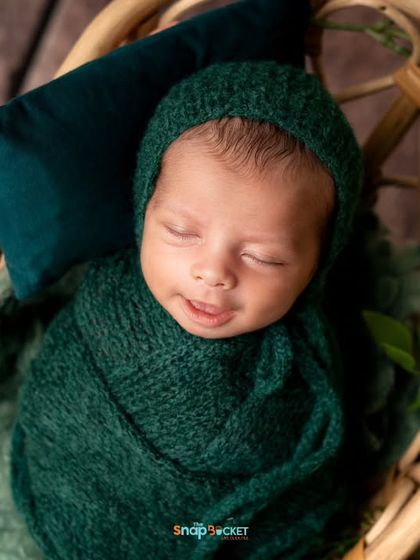 A sweet smile from a sleeping baby. Wrapped in a deep green knit, this little one looks so peaceful. I'm always watching for these fleeting, precious moments.